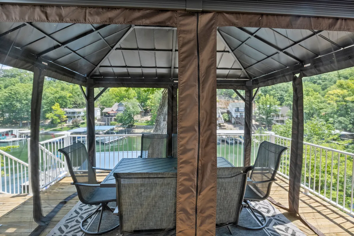 A peaceful exterior scene highlighting a gazebo with a dining table, offering lake views and surrounded by greenery. The setting encourages outdoor relaxation, shared meals, and scenic enjoyment.